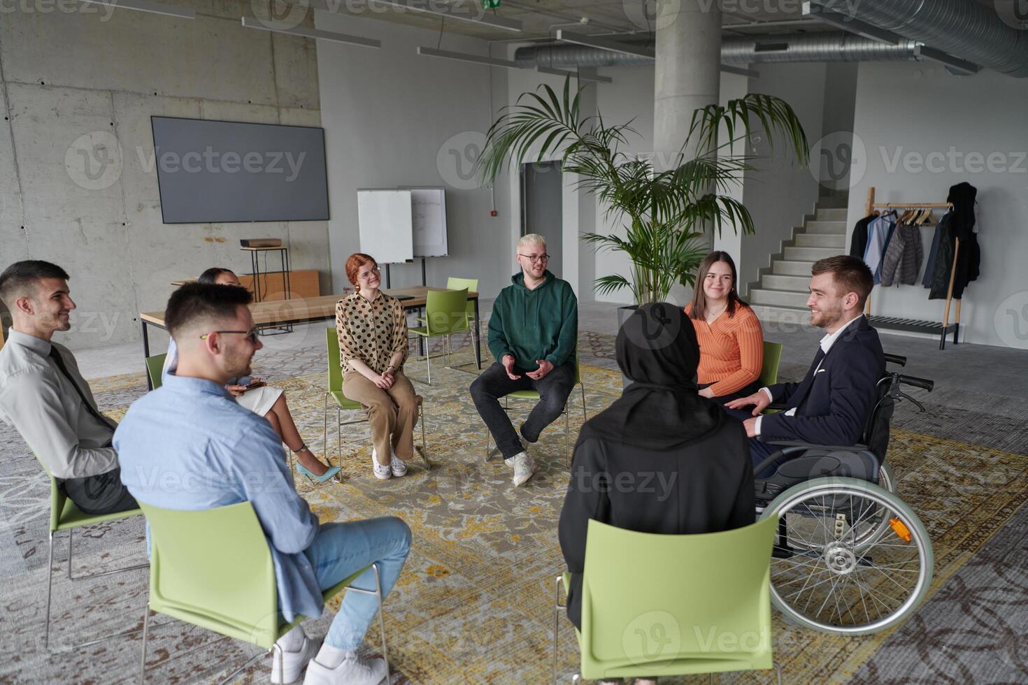 Corporate business team meeting with a manager or coach. Group of happy diverse, multiracial people sitting in a circle photo