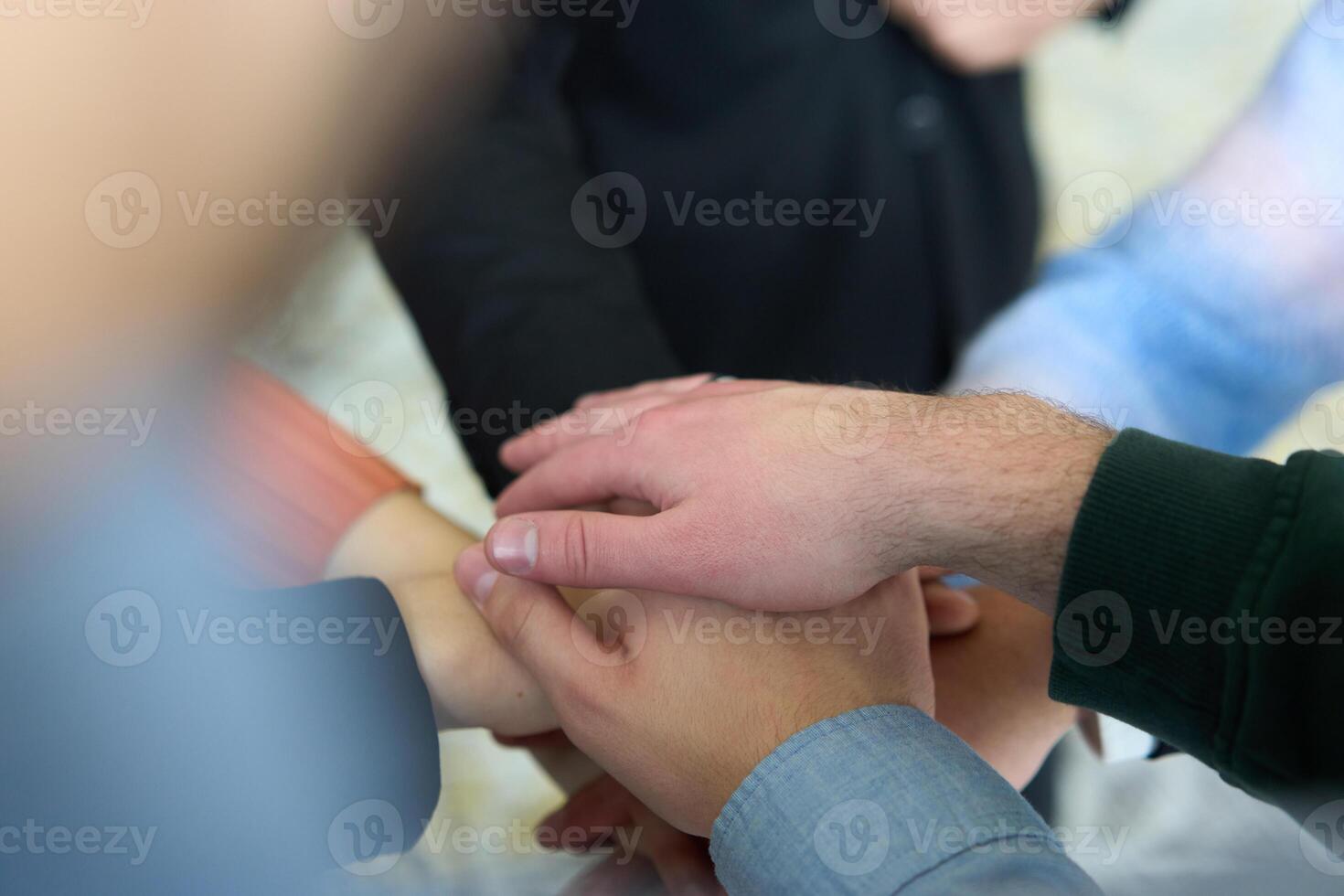 A top view of business people joining hands in a circle, symbolizing unity, collaboration, and shared success in the workplace photo