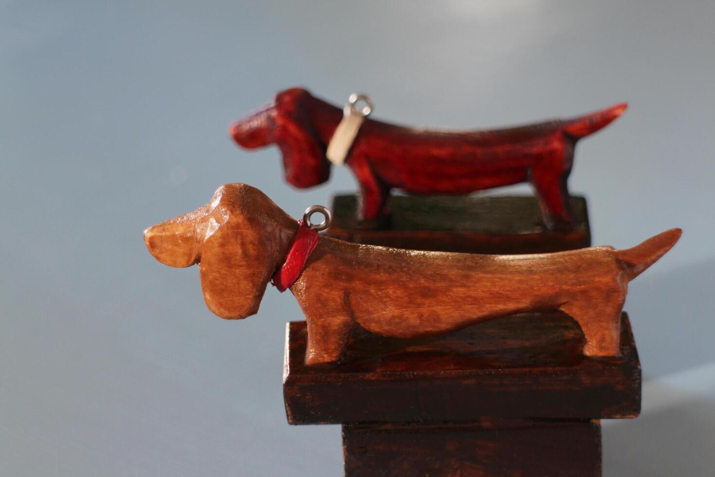 Dachshund dog with collar. Wooden carved figurine Side view. Still life photo
