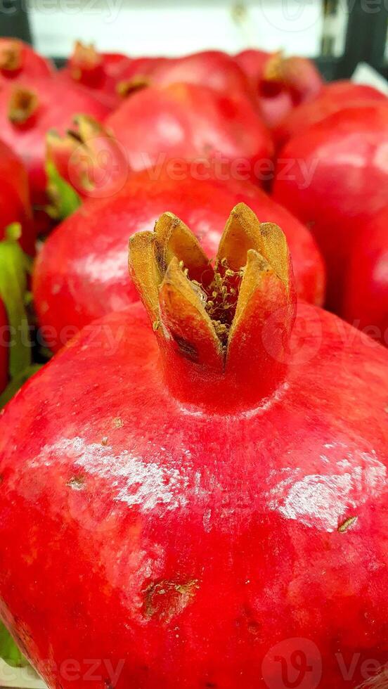 cerca arriba de el madurar granada fruta. rojo Fresco granate Fruta en el mostrador en el mercado foto