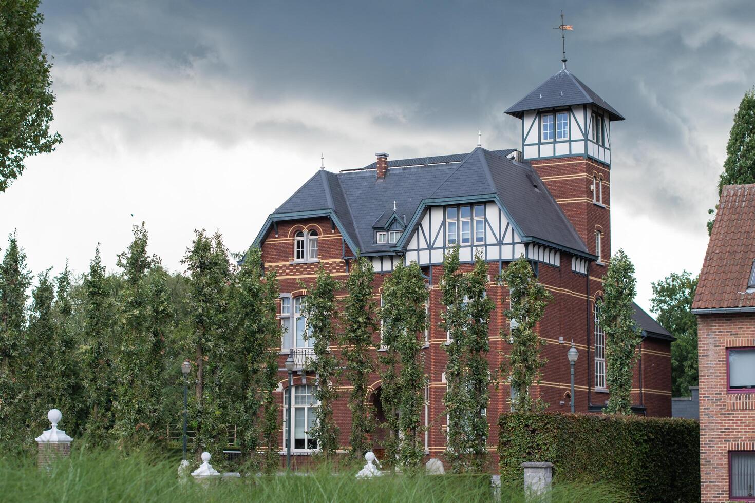 Detached three-storey villa in eclectic style with cottage style elements, built around 1910,against stormy sky and green trees,Belgian cultural heritage,Architecture,Belgium,Bree,September 18, 2023, photo