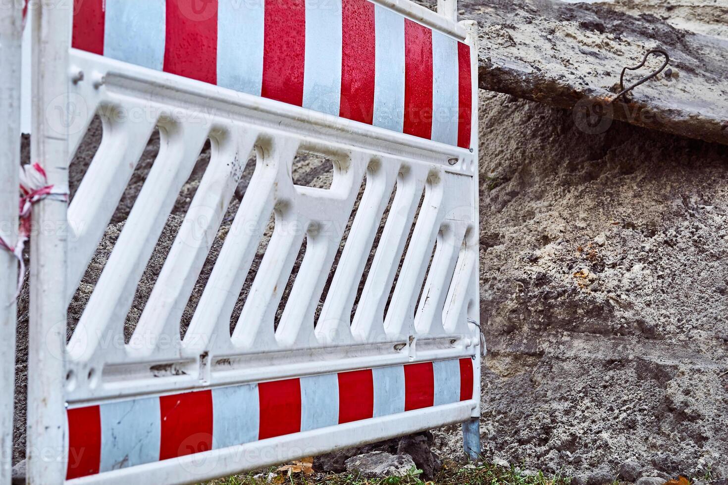 Plastic fencing of a dug pit on construction site photo