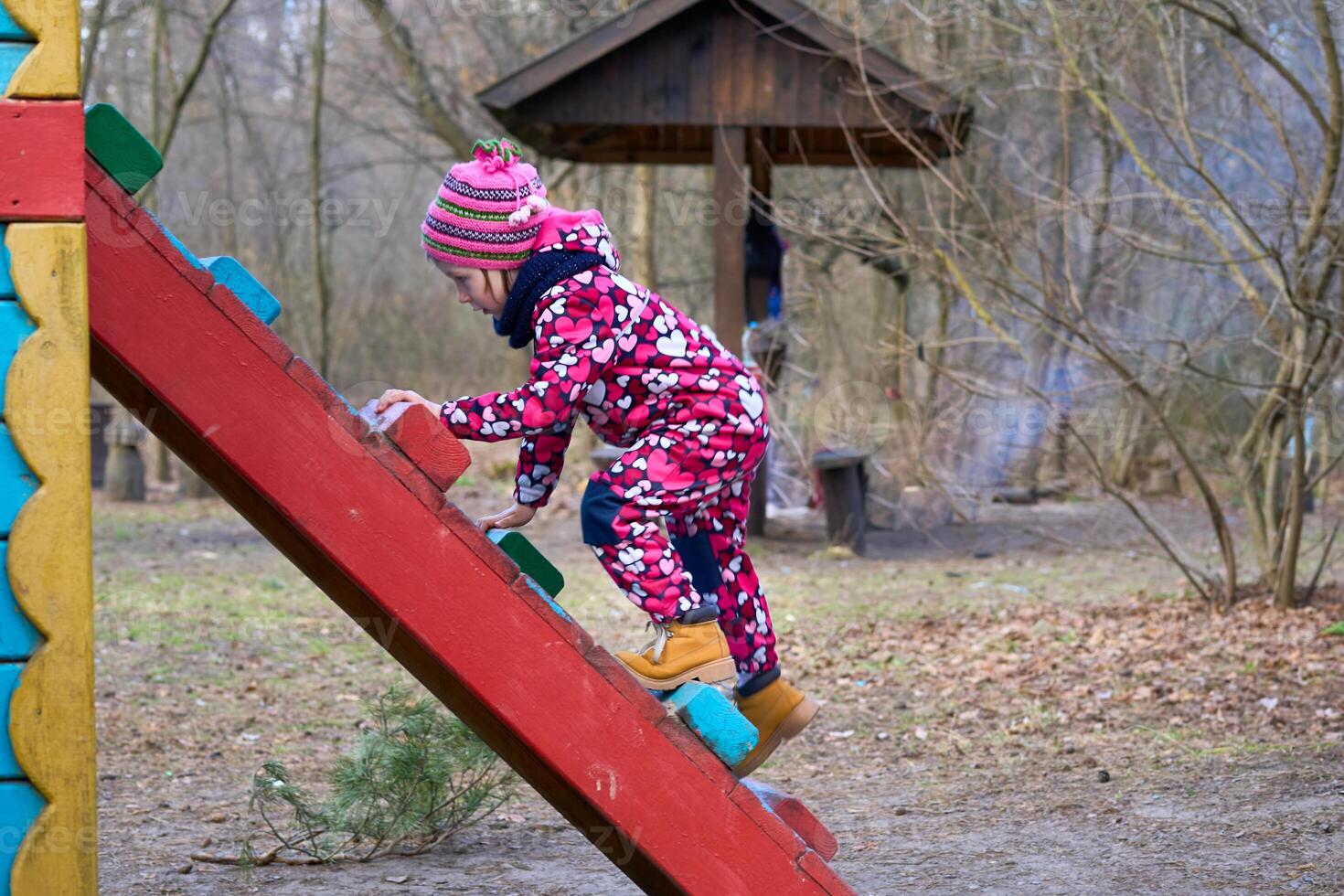 Cute child playing on the ladder at the playground photo
