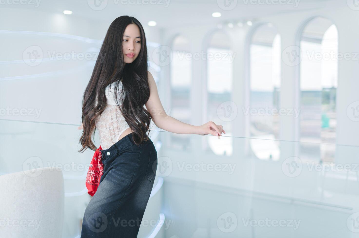 Young Woman in Stylish Outfit Posing in Modern Bright Interior Space photo