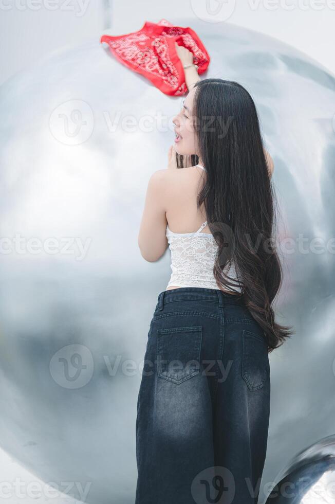 A woman is standing on a silver ball photo