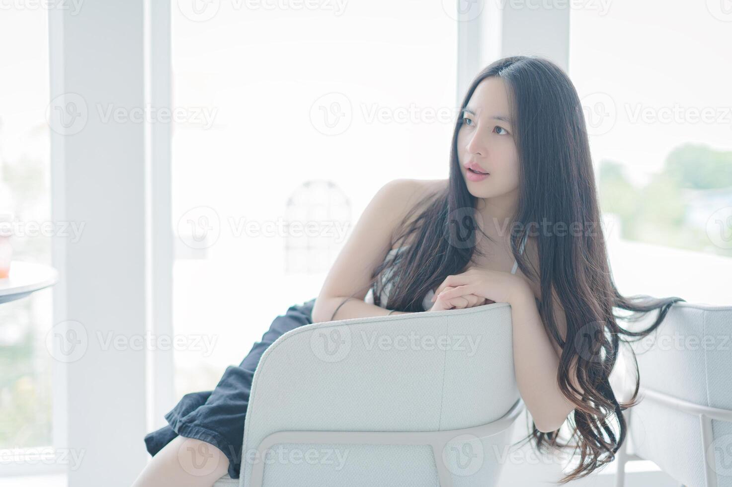 Young Woman with Long Hair Relaxing in Bright Room photo