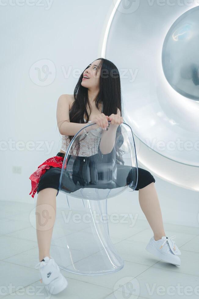Woman Sitting on Transparent Chair in Modern Minimalist Interior photo