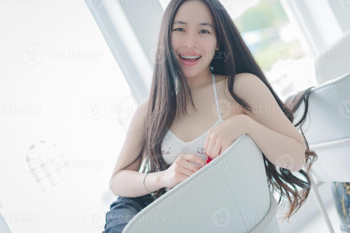 A woman sitting on a chair with long hair photo