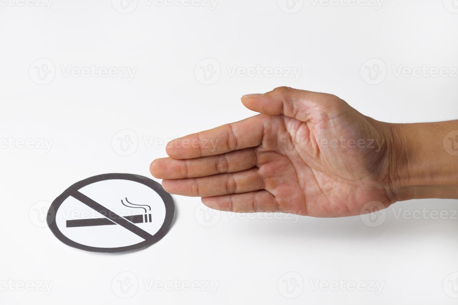 No smoking symbol on round paper held by a man's hand photo