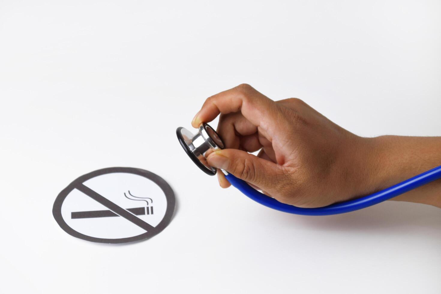 A persons hand holding a Stethoscope examining paper in the smoking ban photo