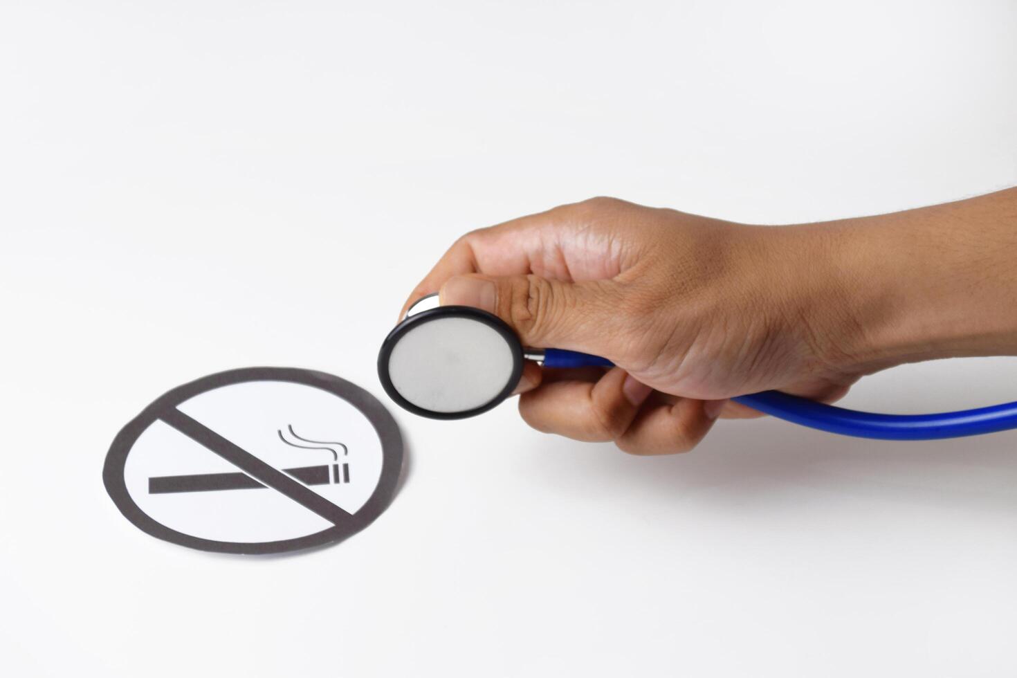 Close up of a hand with a stethoscope inspecting smoking ban paper photo