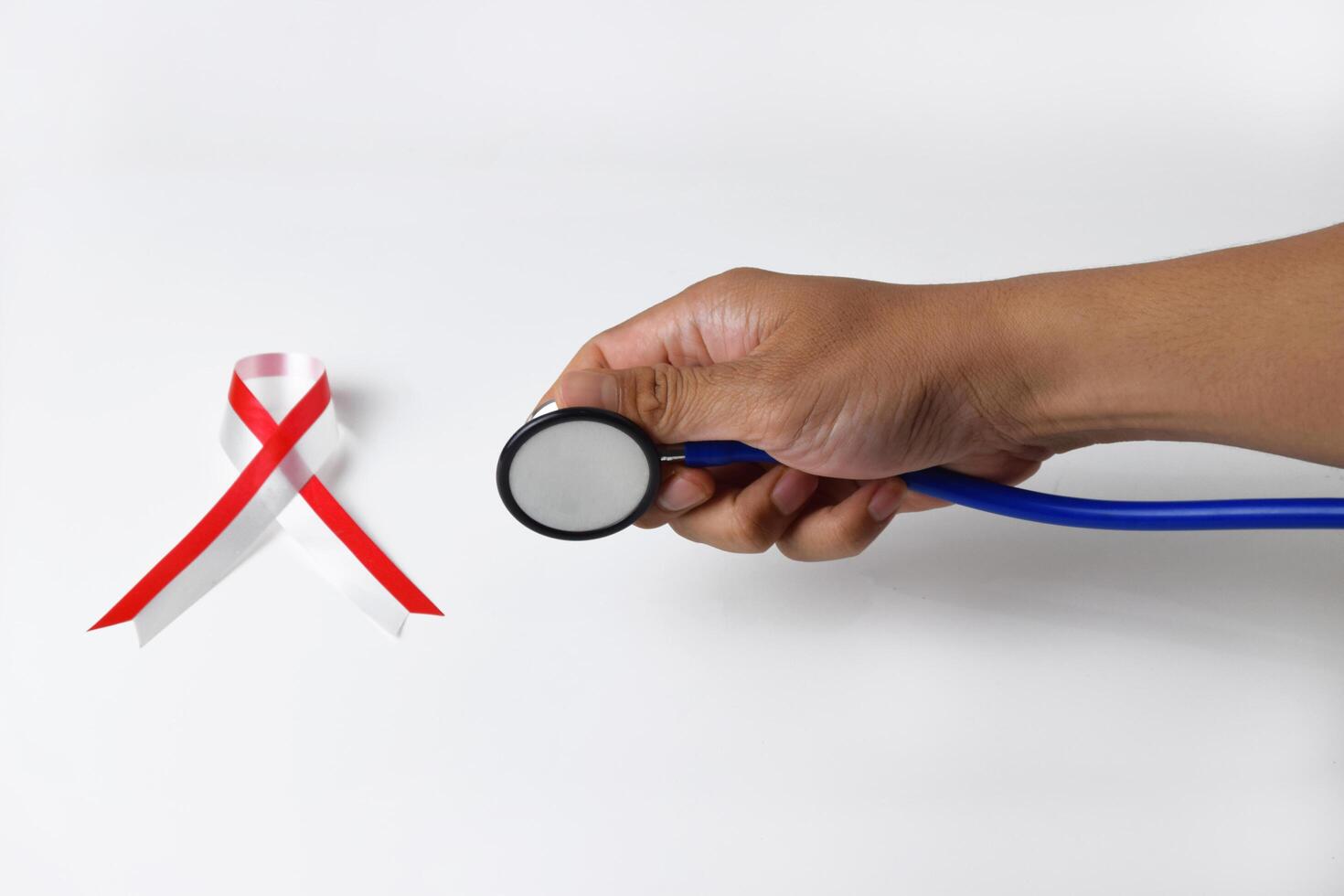 Hands Presenting Stethoscope with Red and White Ribbon photo