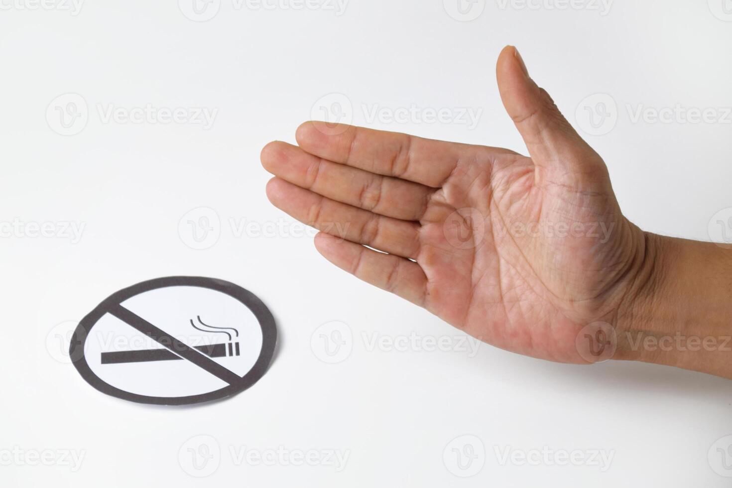 A mans hand with a gesture of refusal or prohibition with a no smoking symbol photo