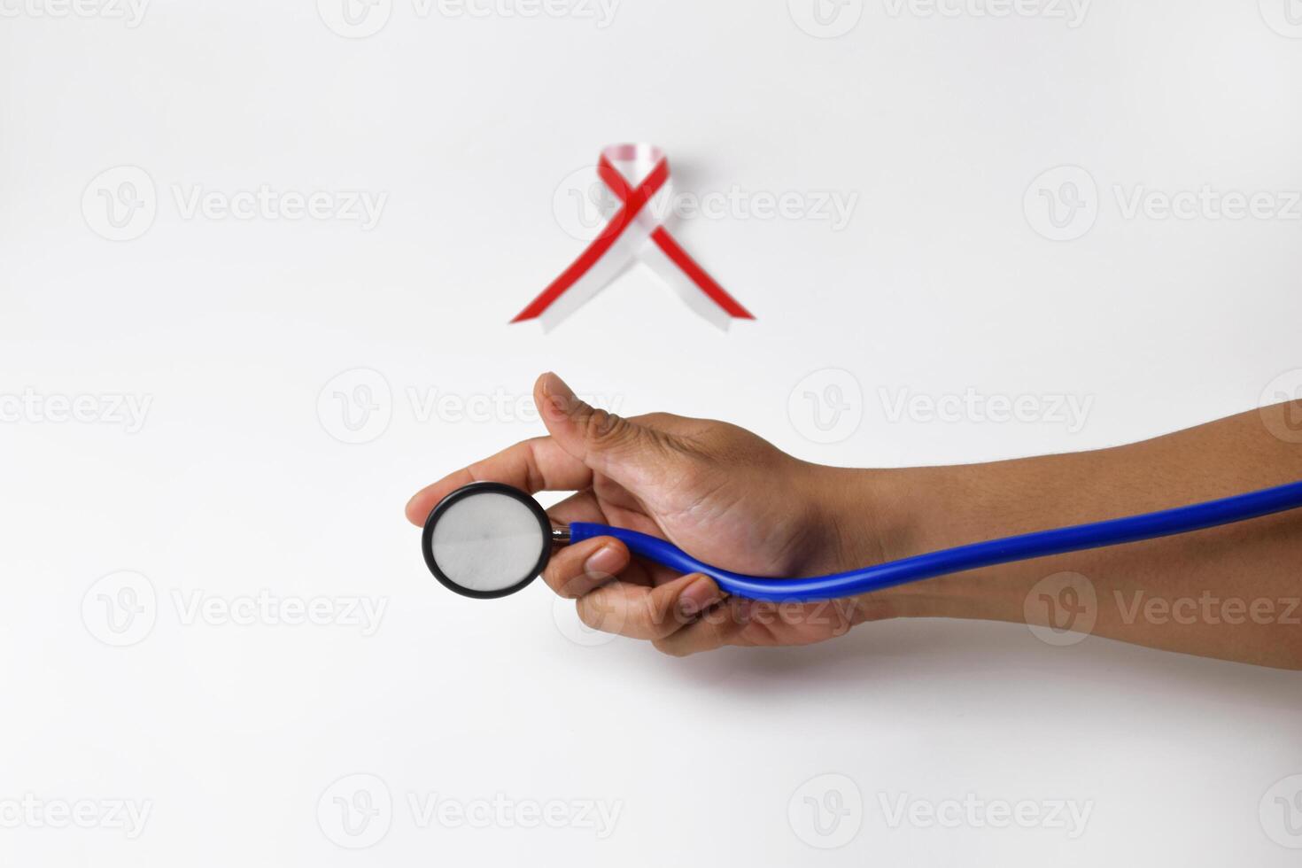 Hand Holding Stethoscope with Red and White Ribbon photo