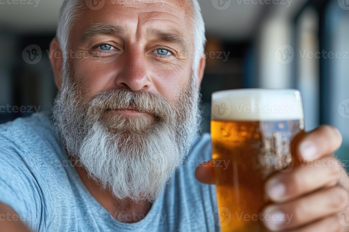 Portrait of senior man drinking beer. He is looking at camera and smiling. photo