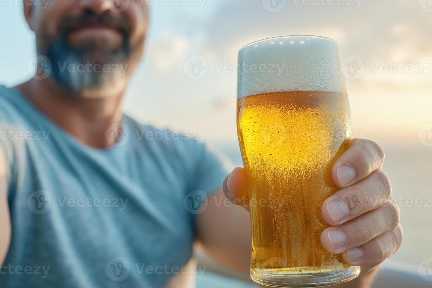 Close-up of a glass of beer in the hands of a man photo