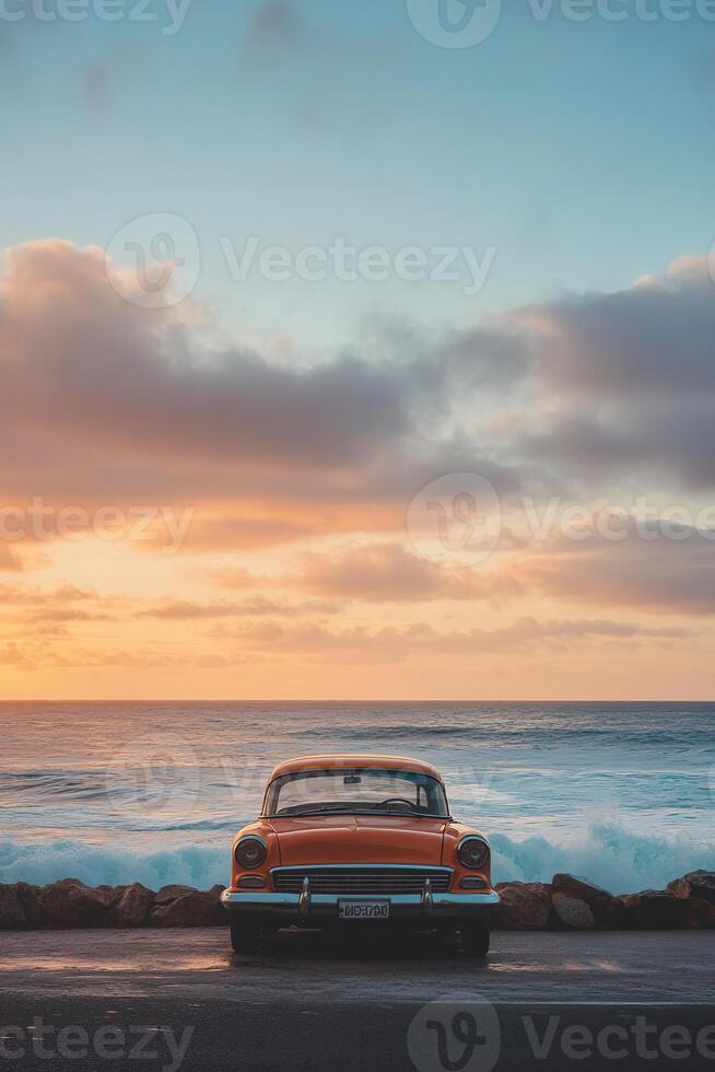 vertical image back view of a red retro car on a seashore with sun rising on a background photo