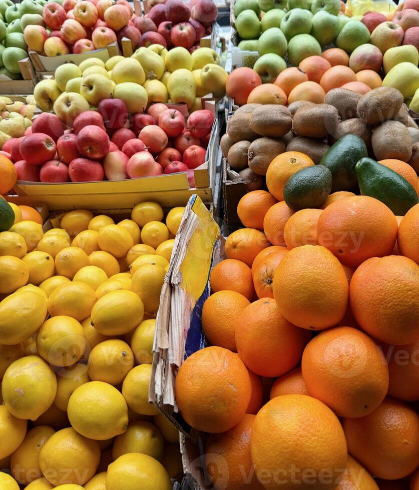 A vibrant open market stall featuring a variety of fresh fruits, including tangerines, lemons, apples, oranges, kiwis and avocado in Serbia photo