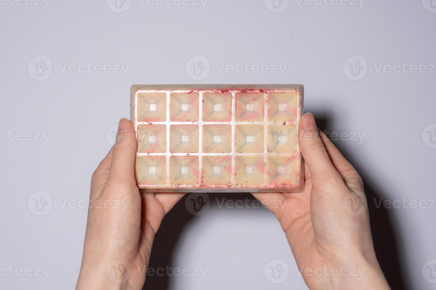 Trend white Dubai chocolate with pistachio, dried raspberry, tahini and kataifi filling, chocolate in woman's hands. Confectionery and handmade sweets, chocolatier photo