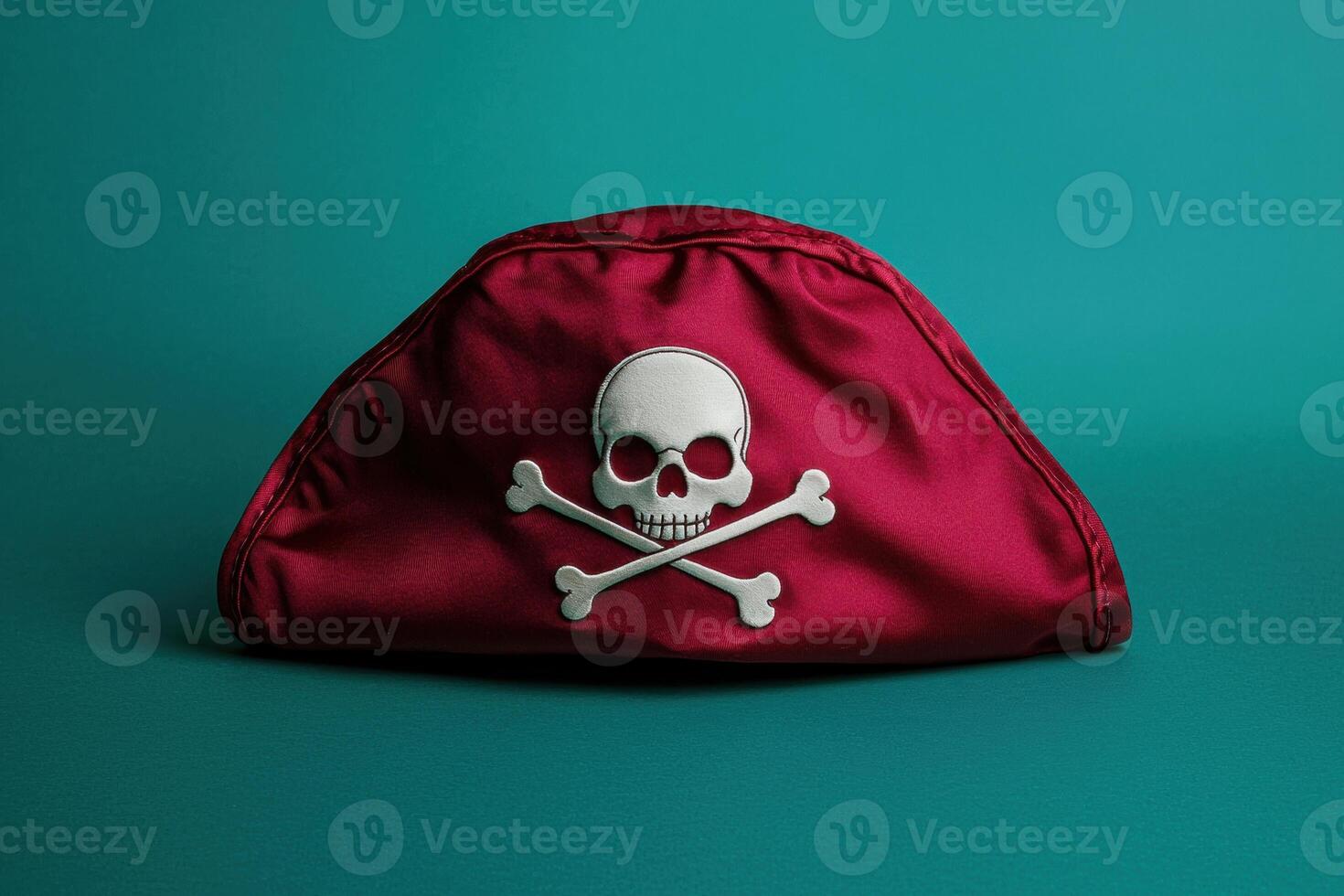 Red pirate hat with skull and crossbones on teal background photo