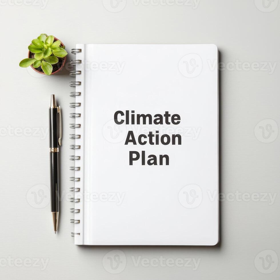 Plan for climate action concept. Notebook with Climate Action Plan text and a plant on a table. photo