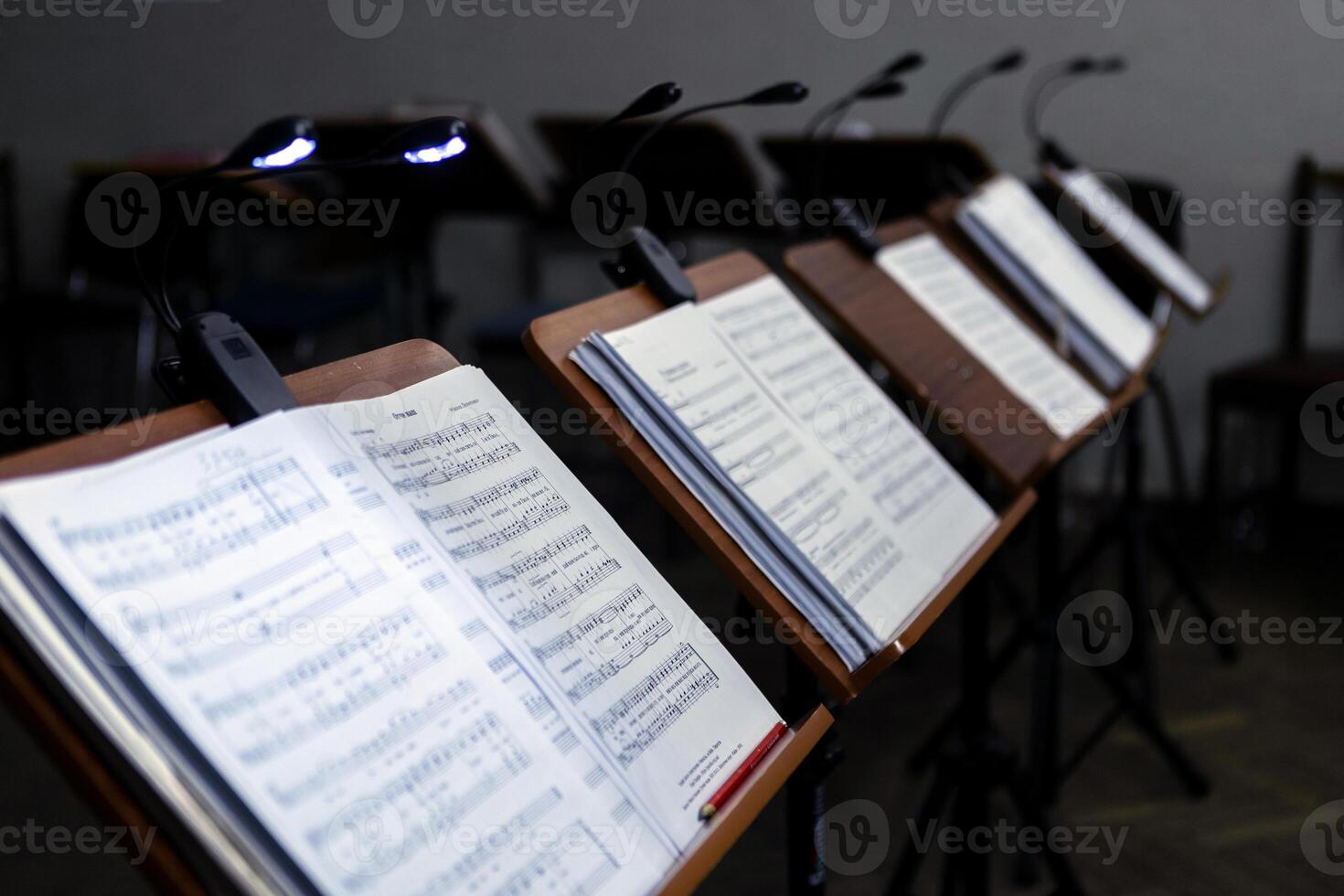 Music stands with musical notes in the rehearsal room, The music stands have lanterns attached to them for lighting. photo