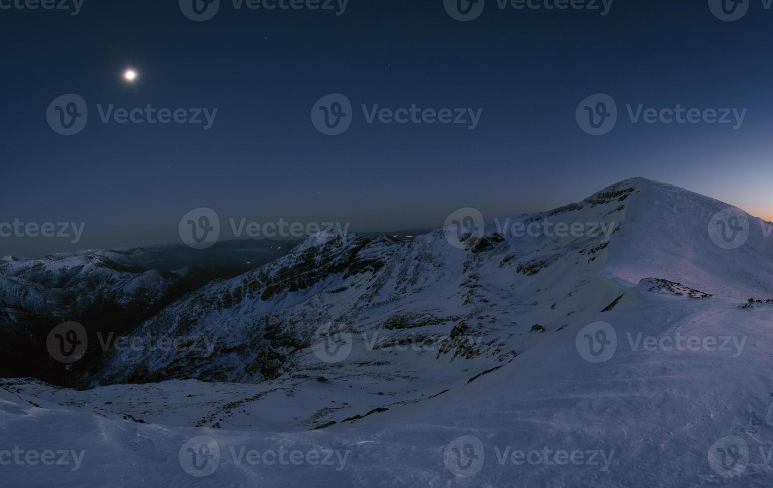 Snowy mountains illuminated by the March full moon photo