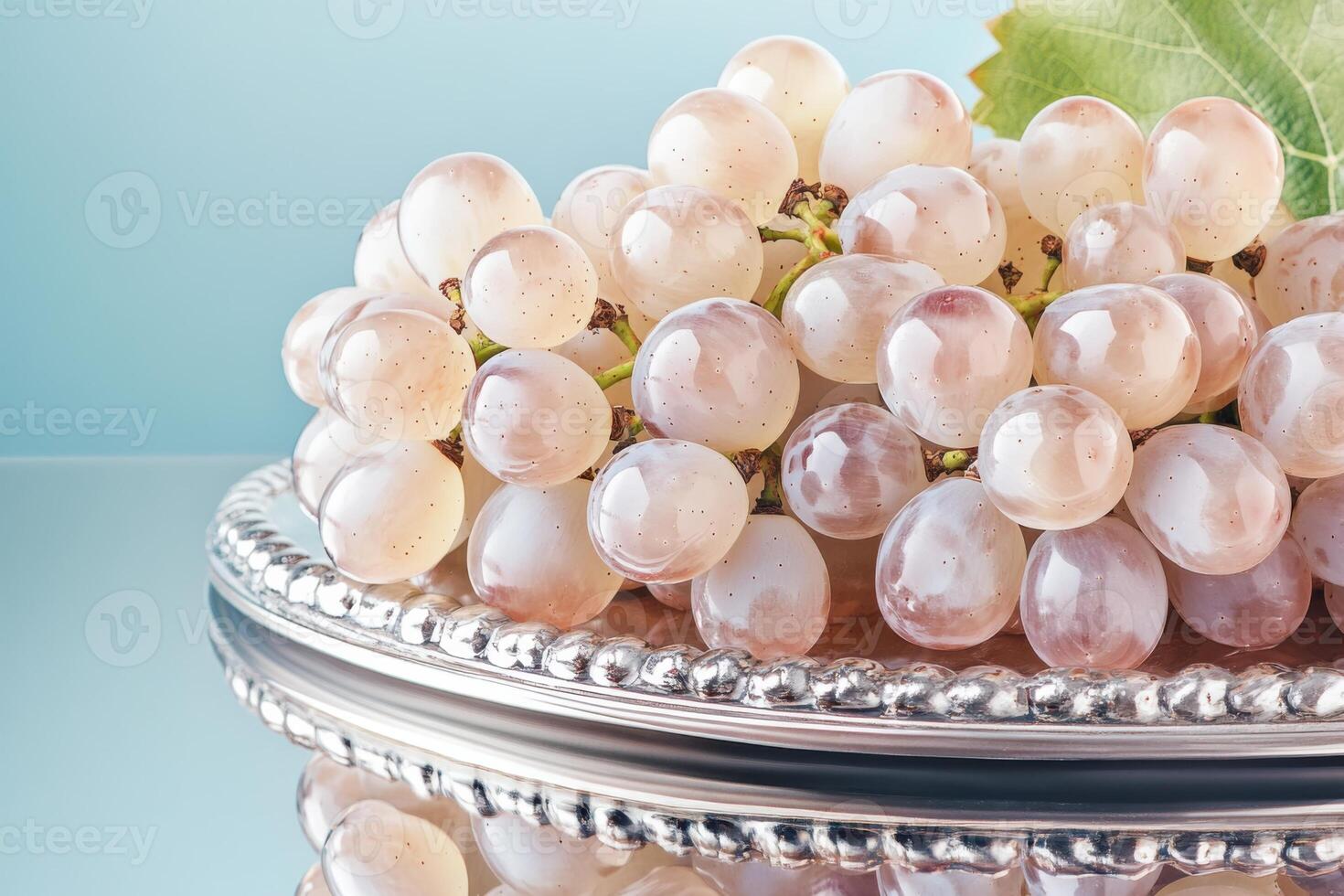 Cluster of shimmering crystal grapes elegantly displayed on a reflective silver platter exuding luxury and sophistication photo