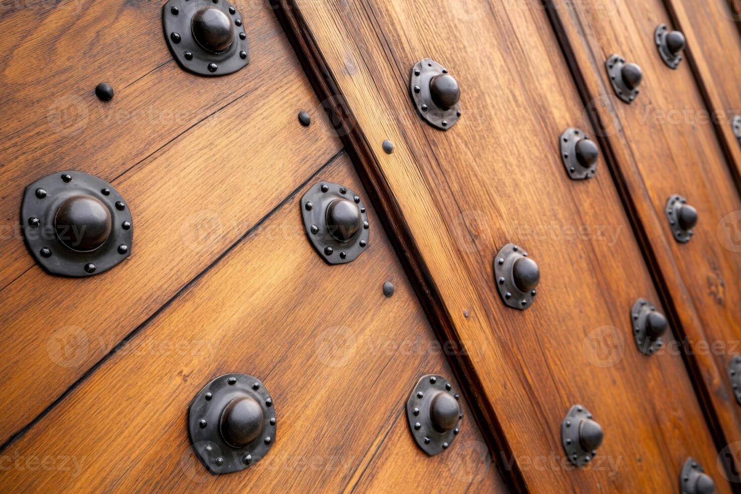 Heavy wooden castle door with iron rivets partially open revealing a dark interior in a historic setting photo