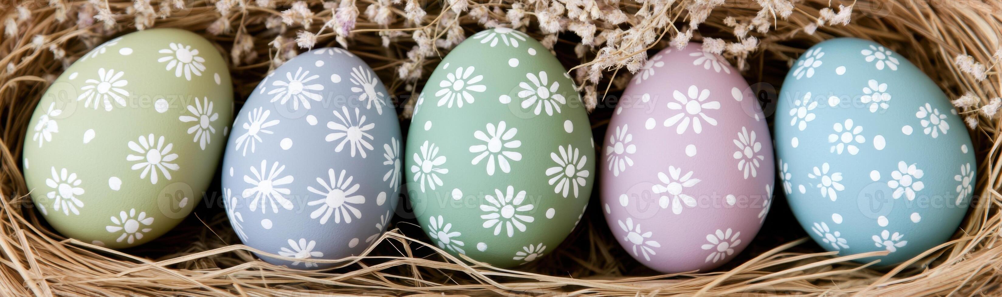 Colorful collection of hand-painted Easter eggs arranged in natural straw with delicate floral patterns photo