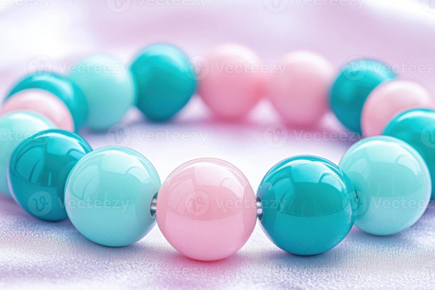 Colorful beaded bracelet featuring mint, teal blue, and pastel pink beads on a soft textured surface with gentle shadows photo