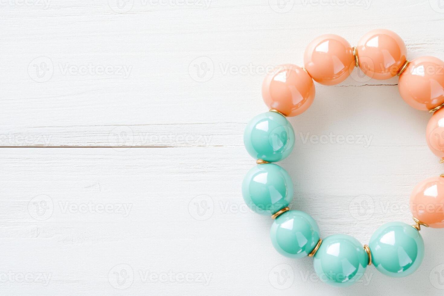 Colorful mint and peach bead bracelet resting on a light wooden surface in a bright and airy setting photo