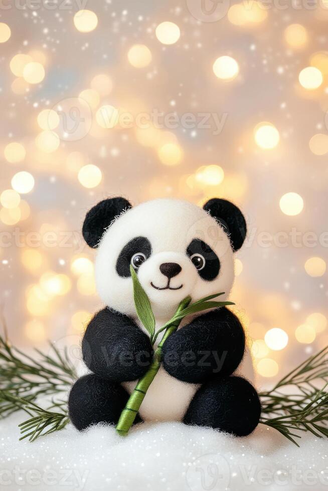 Miniature black-and-white panda holding bamboo on a soft snow patch with pastel lighting in a cozy atmosphere photo
