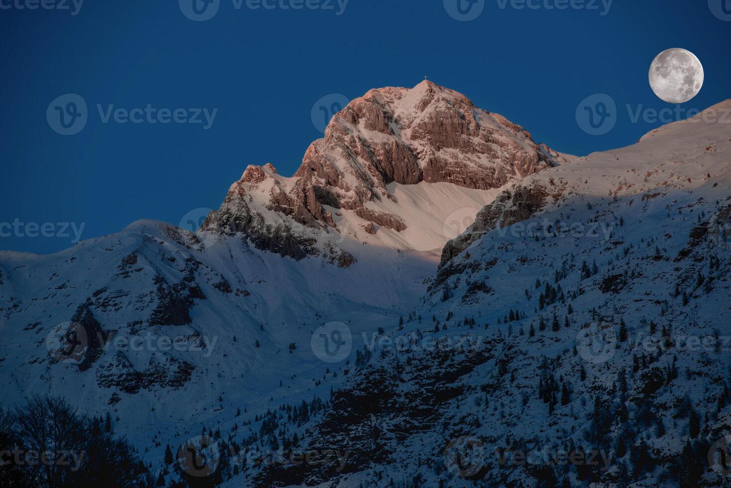 a snowy mountain range is seen in the sunset photo