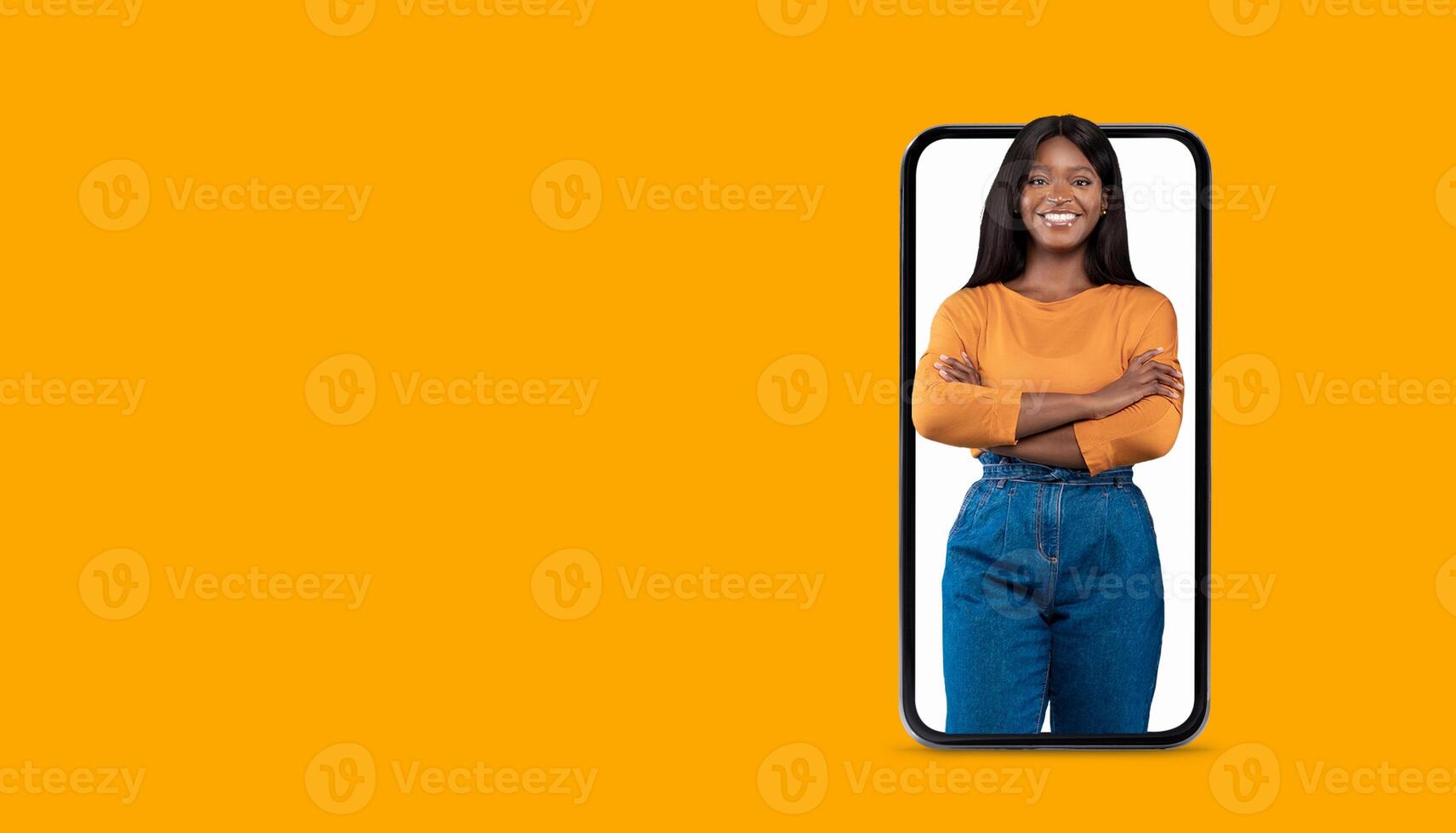 A person stands confidently inside a large smartphone screen, smiling warmly. The vibrant orange background adds energy, highlighting the theme of social media communication and technology. photo