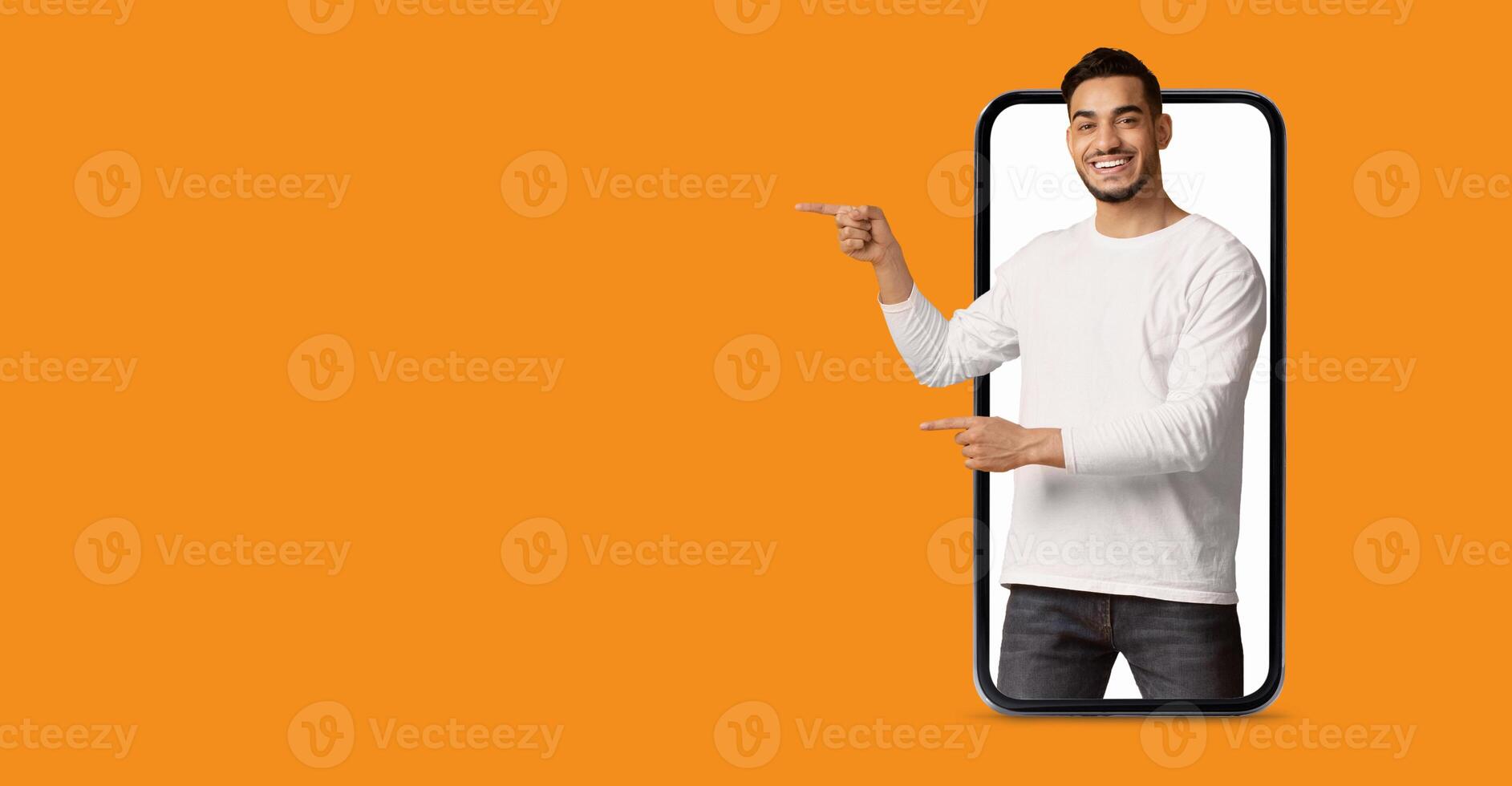 A man is actively engaging with a large smartphone screen, pointing to various applications. The vibrant background enhances the focus on technology and modern communication. photo