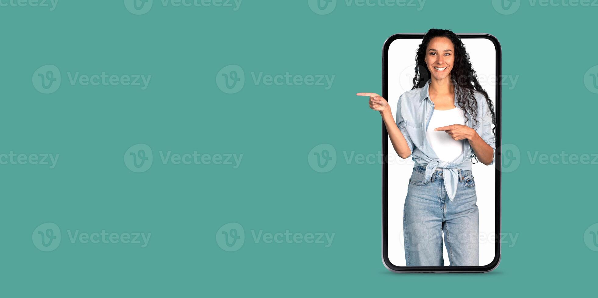 A woman interacts with a smartphone, happily showcasing an online application. The setting features a solid color background, emphasizing the focus on communication technology. photo