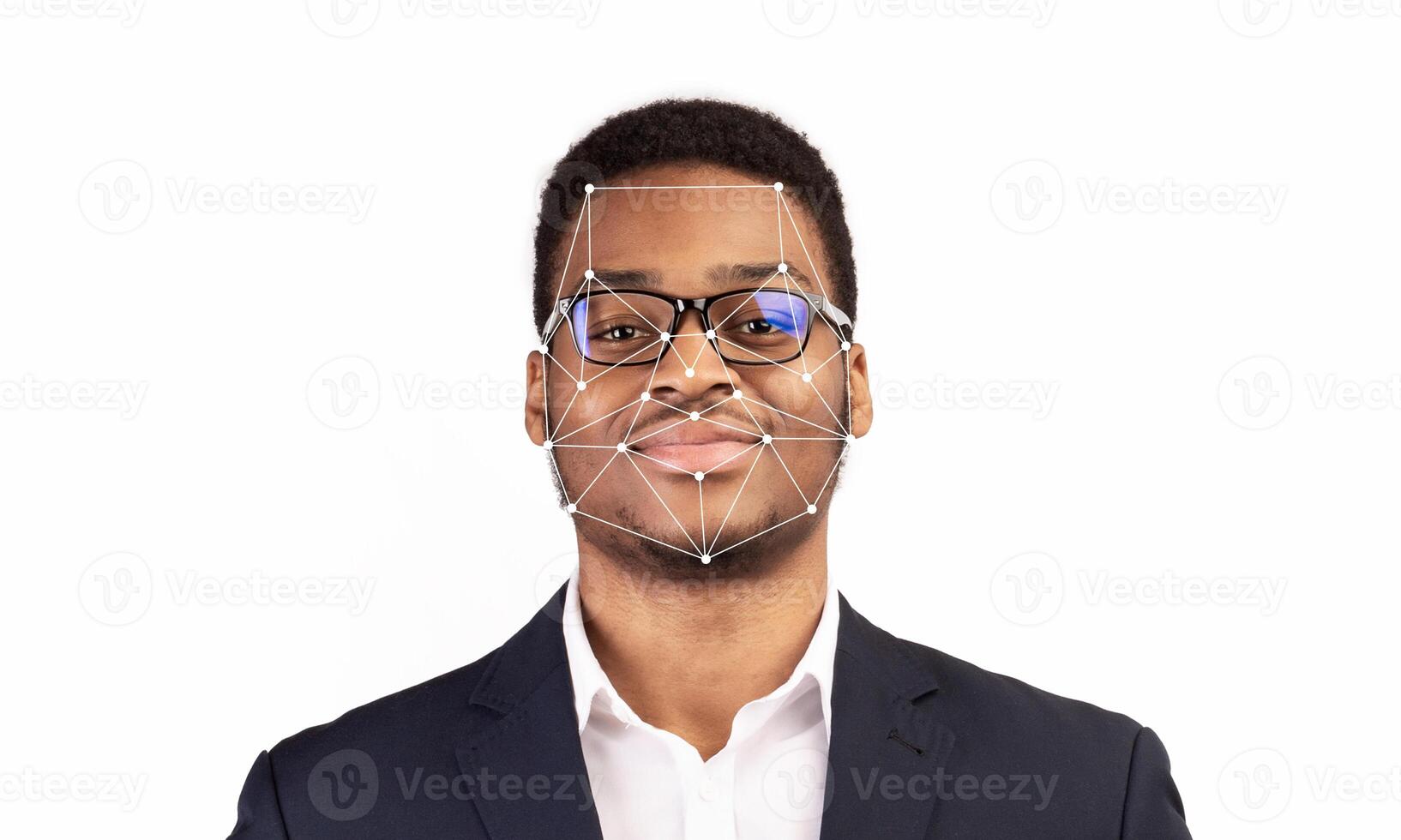 A young man wearing glasses and a suit is displayed against a plain background. Facial recognition markers overlay his face, illustrating how modern technology identifies individuals. photo