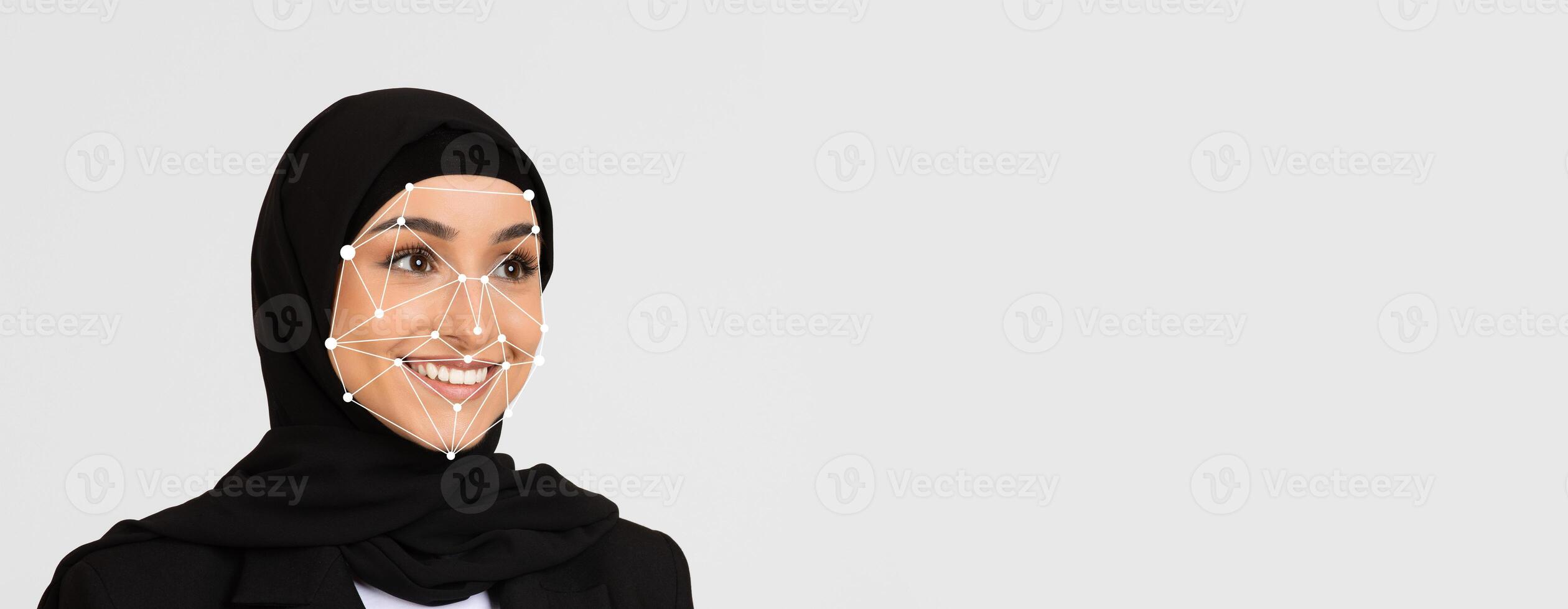 This visual focuses on a woman wearing a hijab, smiling, as facial recognition technology highlights key facial features against a simple backdrop, emphasizing identification and technology. photo
