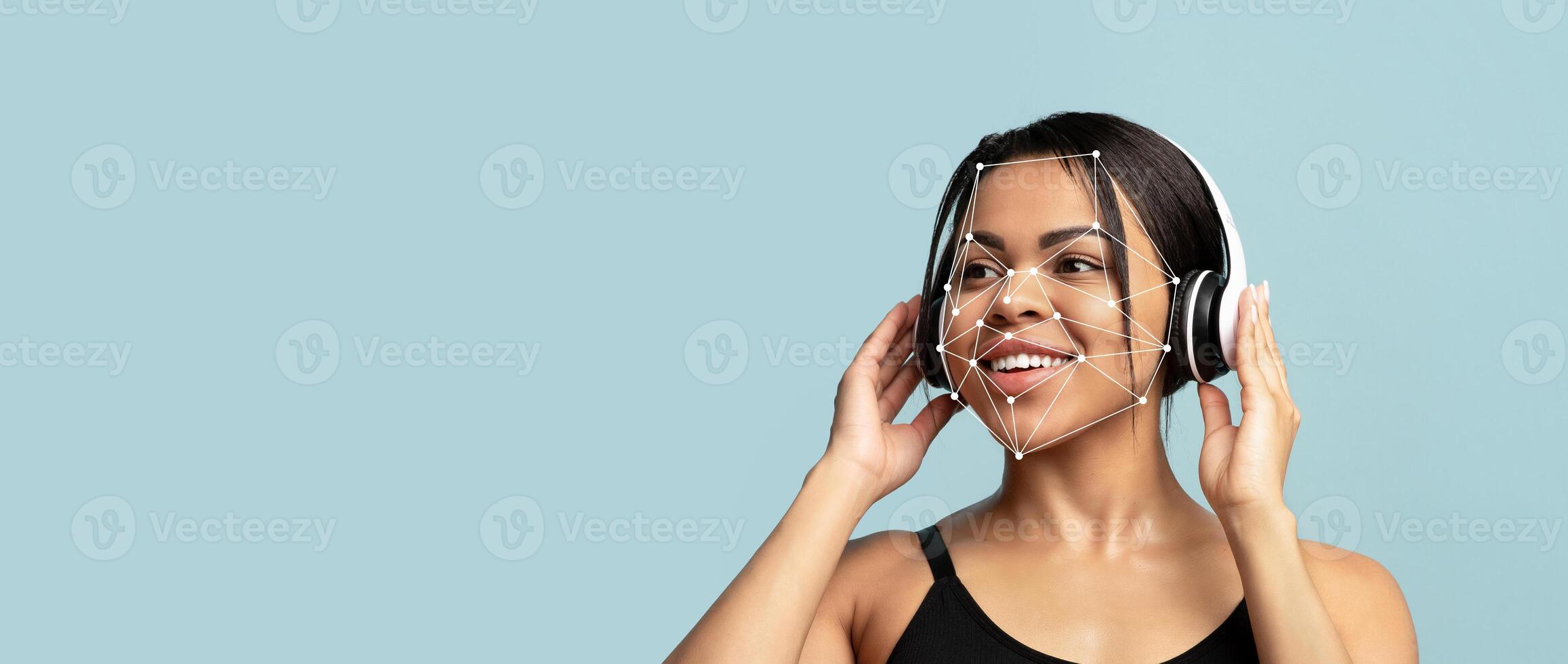 A woman with headphones smiles as facial recognition technology overlays her features. The background is a soft blue, emphasizing the connection between technology and human expression. photo