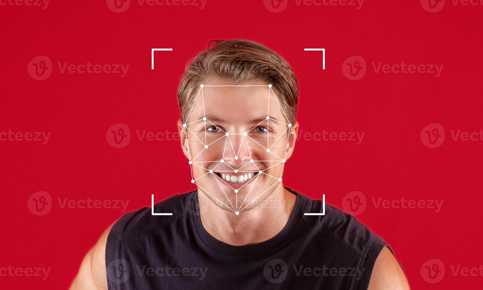A man with a joyful expression is captured in front of a red background. Facial recognition software marks key points on his face, demonstrating advanced identification technology. photo