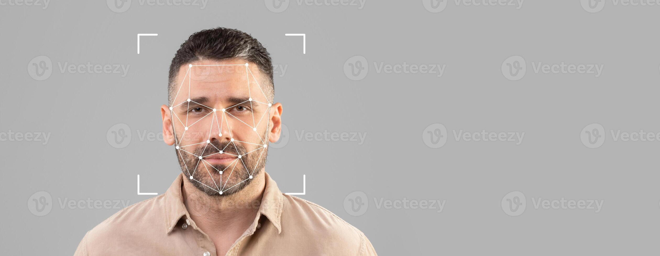 A man is isolated against a blank background while facial recognition technology scans his features for identification. The image focuses on the intricate facial mapping process. photo