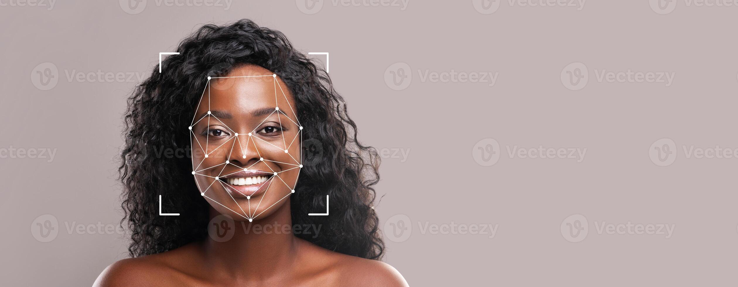 A person with curly hair smiles while facial recognition technology scans their features. This modern identification method focuses on enhancing security and user experience. photo