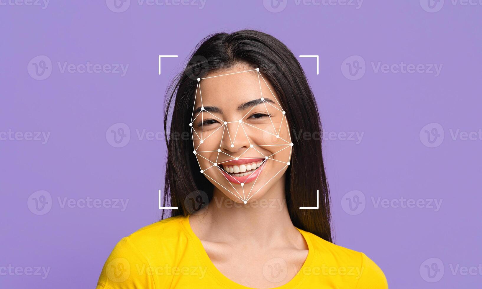 A woman with long, dark hair smiles while facial recognition technology maps her face. The background is a solid purple, emphasizing the facial identification process and her expression. photo
