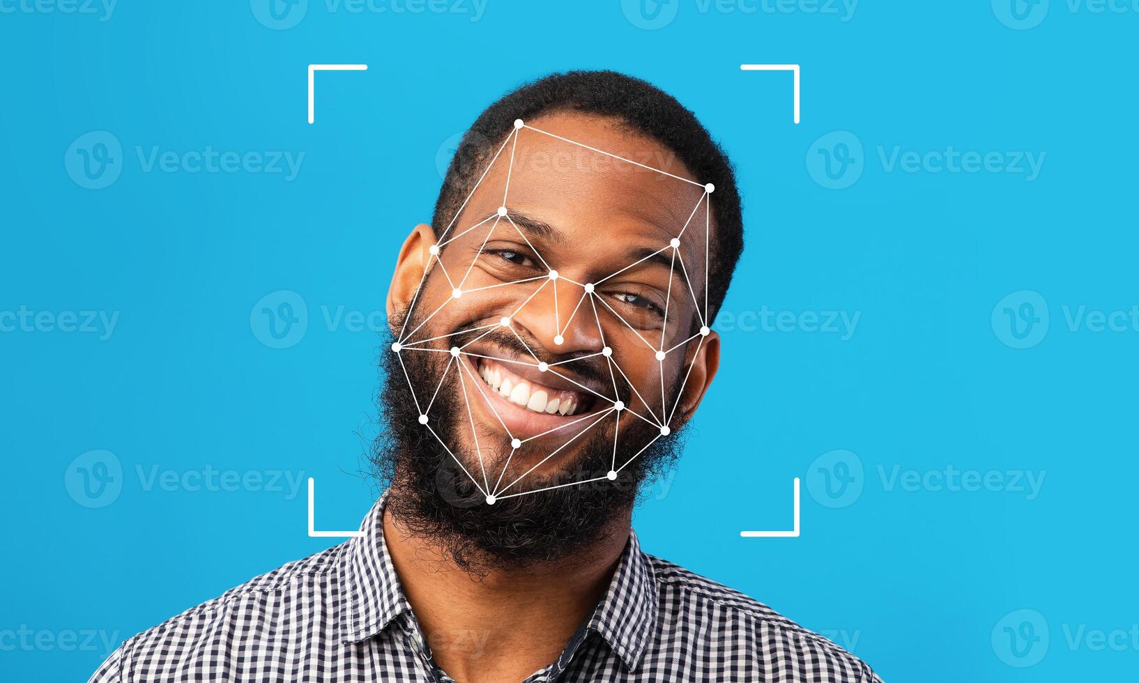 A man with a beard smiles brightly against a solid blue background. Facial recognition technology is overlayed on his face, displaying points of identification for analysis. photo