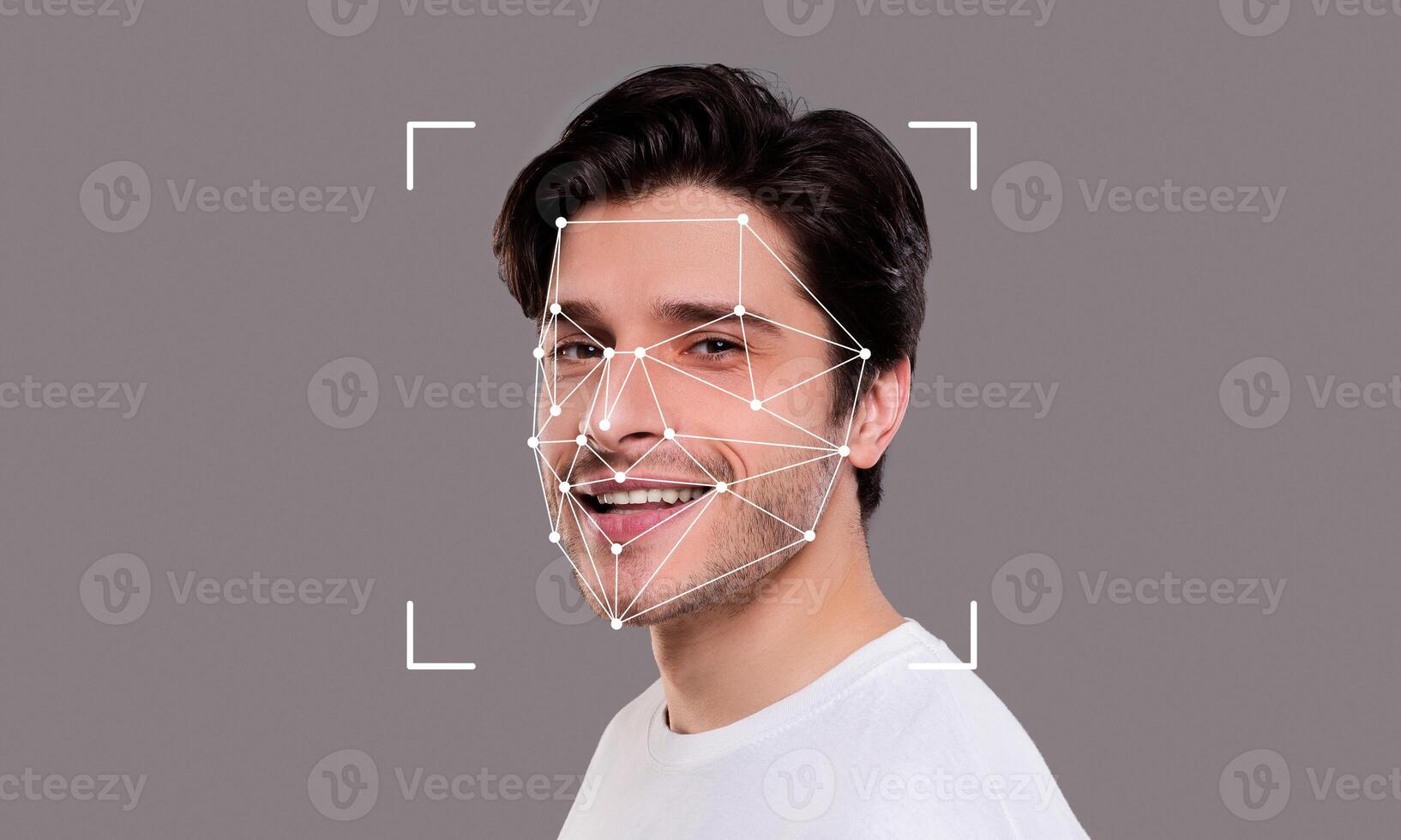 A young man smiles while facial recognition technology analyzes his features. The digital overlay highlights key facial points for identification. photo