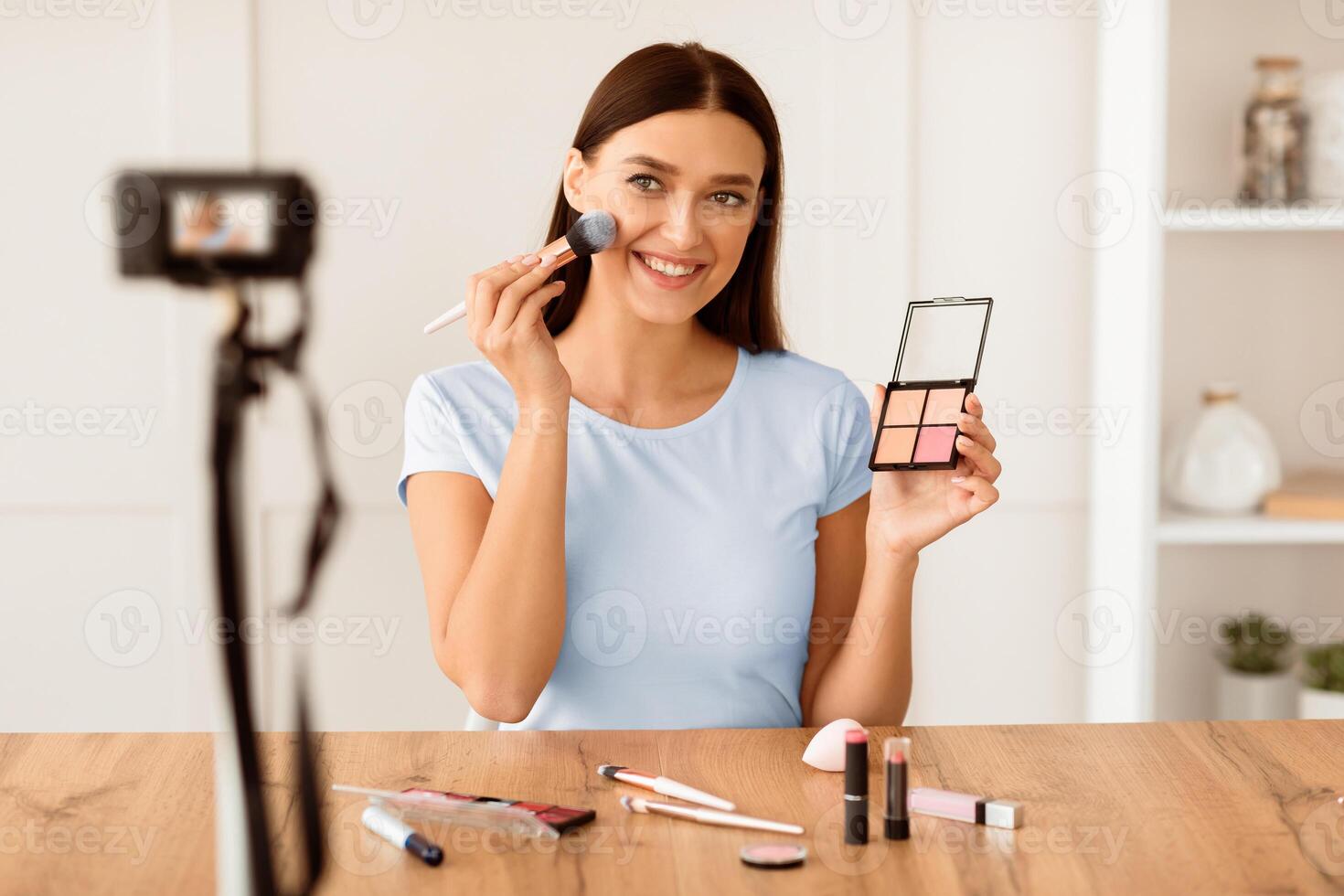 Girl Creating Beauty Blog Making Teaching To Make Makeup And Use Cosmetics Sitting At Camera At Home. Selective Focus photo