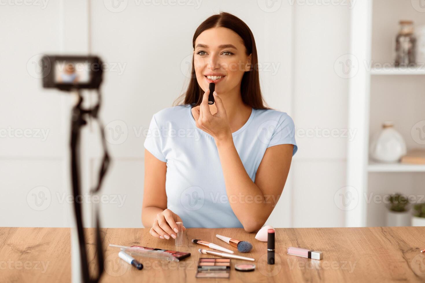 Beauty Blogger Girl Making Makeup Tutorial For Blog Teaching To Use Cosmetics Sitting Indoors. Selective Focus photo