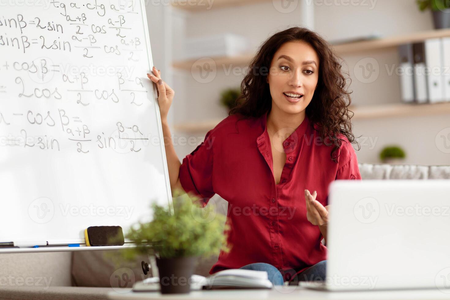 Modern Distance Learning. Math teacher making conference chat with students using pc laptop. Confident woman teaching from home. Homeschooling during quarantine and coronavirus outbreak. photo