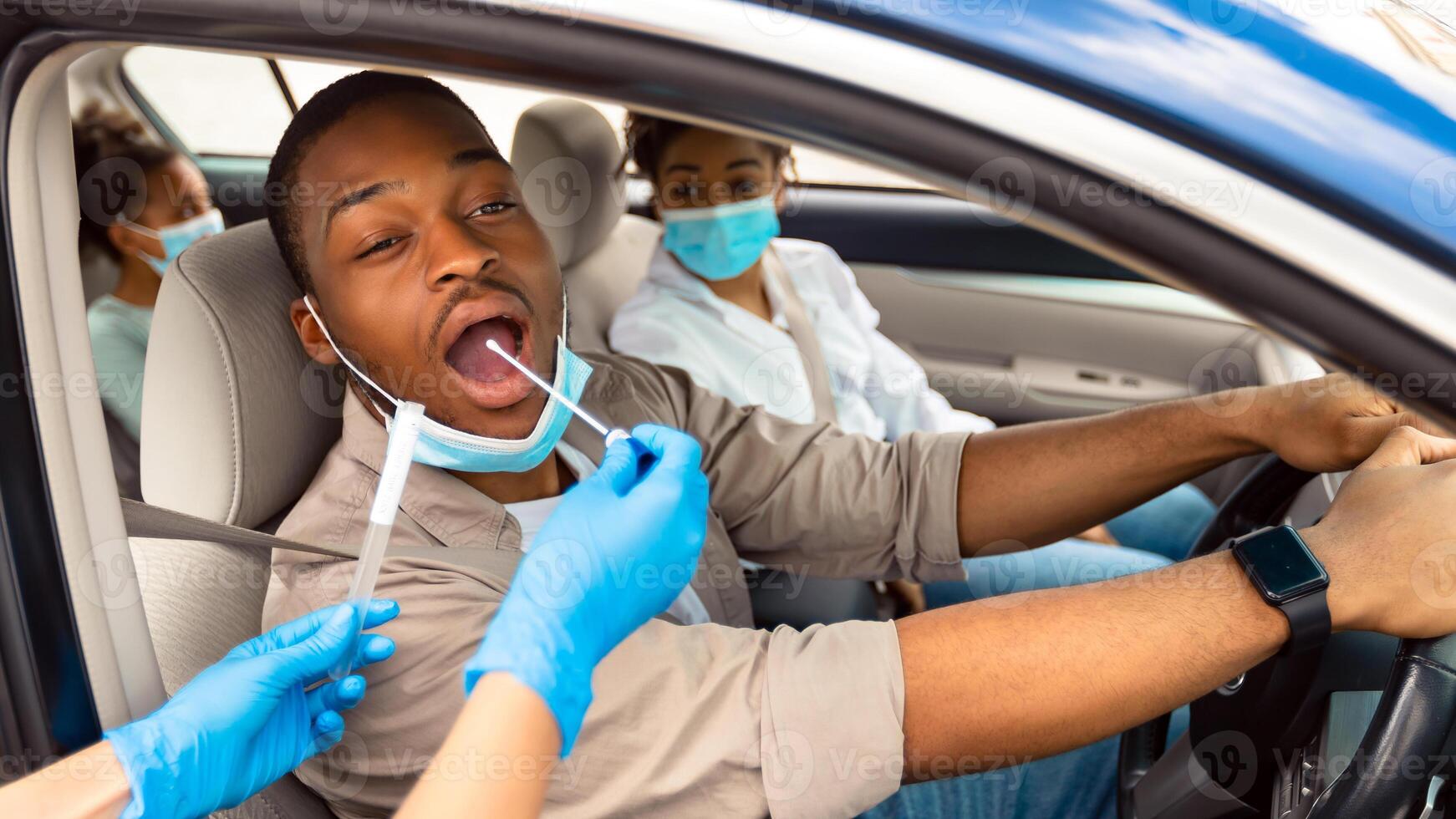 African American Family Getting Tested For Covid-19 Sitting In Car, Wearing Protective Face Masks. Drive-Thru Covid Testing Site Concept. Coronavirus Diagnostic, Pandemic Outbreak photo
